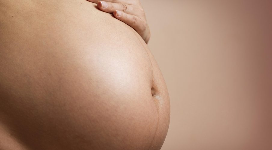 Ciężarny brzuch kobiety w ciąży widziany z bliska