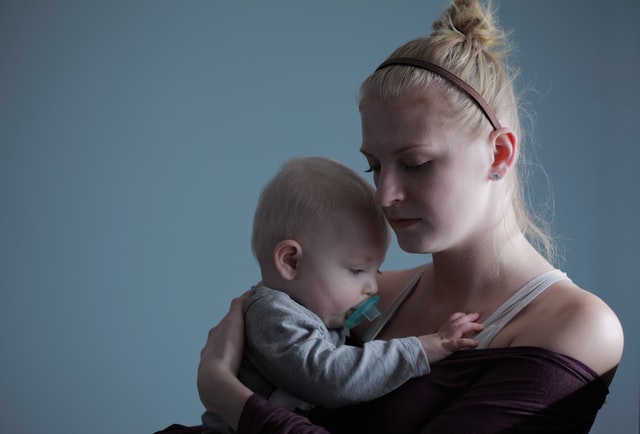 Młoda mama z dzieckiem na rękach